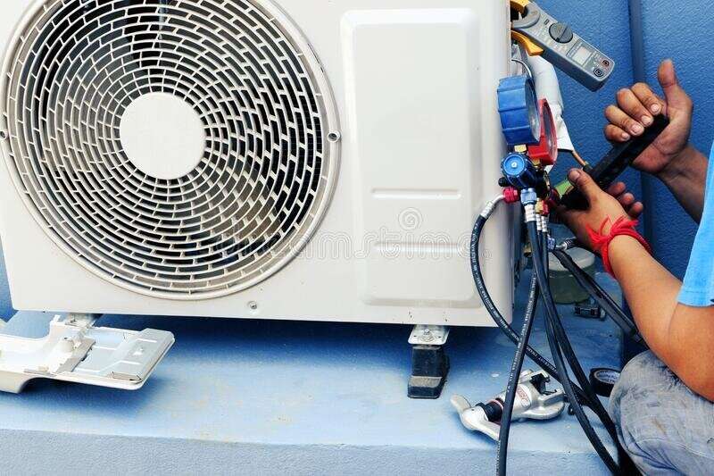 air conditioning technician repairing air conditioner